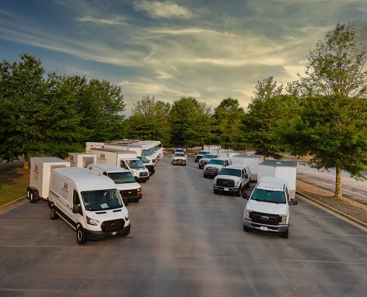 Fleet of Hanna Brothers catering trucks and vans parked on site