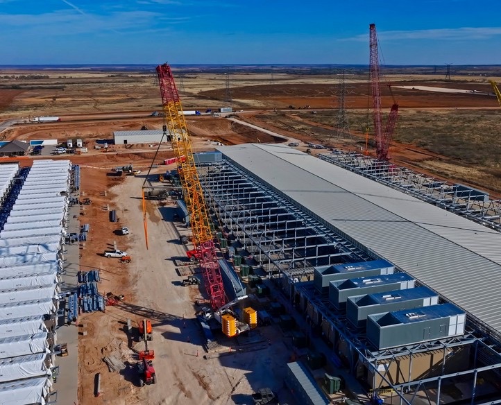 Aerial view of a large data center under construction with cranes on site
