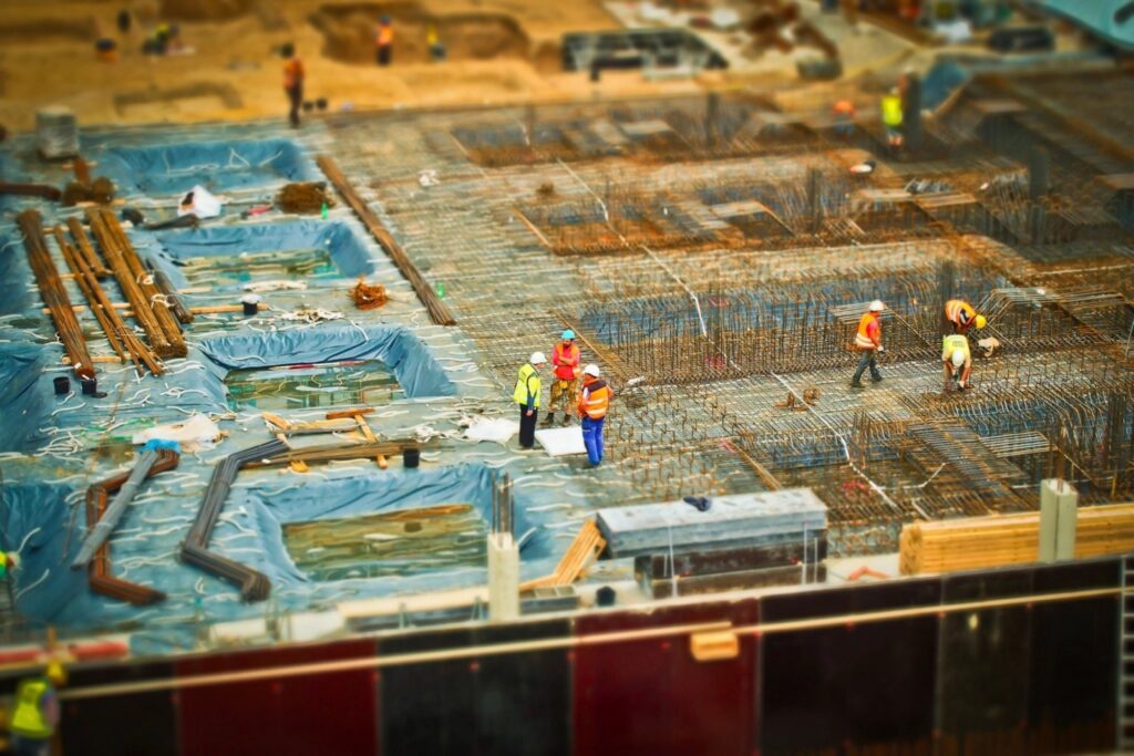 Crews working on a large construction site in hard hats and high-visibility vests